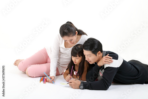 South East Asian father mother daughter parent child study read write talk on floor white background pencil paper © oqba