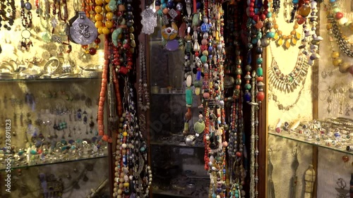 Traditional Moroccan Marrakech bazaar with arabian handmade craftsman neck decoration, beads with colorful stones, souvenirs in a market stall. 