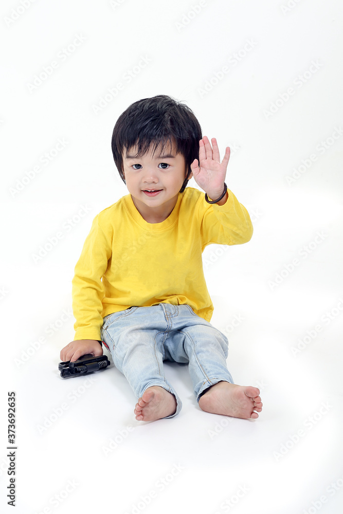 South East Asian young boy child playing happy waving hand at camera on white background South East Asian young boy child playing happy waving hand at camera on white background