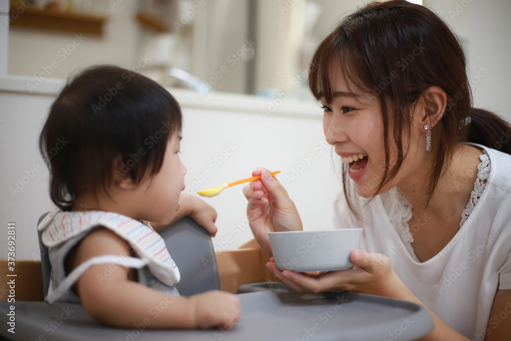 赤ちゃんに離乳食を与える母親 赤ちゃんに離乳食を与える母親