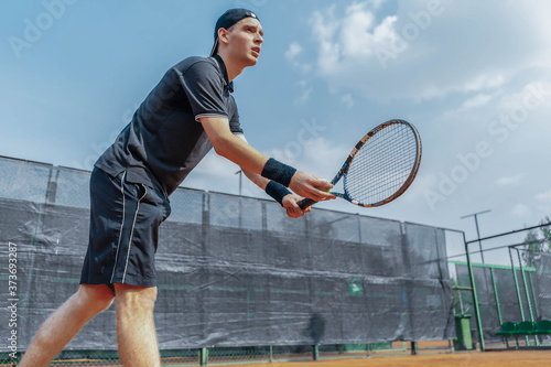 Distant Plan of Man Tennis Player Prepares to Serve a Tennis Ball At Match. Player Holding Outfit In Both Hands to Serve A Ball With Straighten Strike
