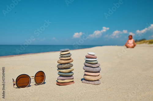 Cairn of stones and sunglasses on a sandy beach