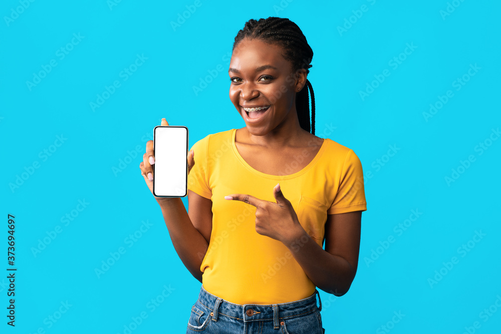 African Girl Showing Mobile Phone Empty Screen Over Blue Background African Girl Showing Mobile Phone Empty Screen Over Blue Background