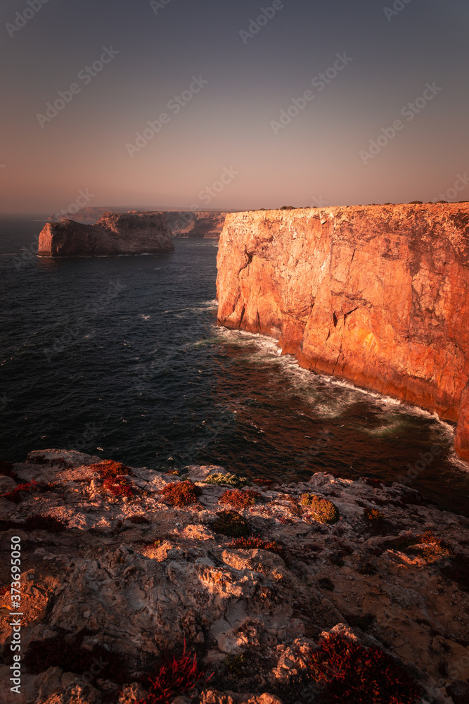 High red cliffs around Sao Vicente cape at south-west corner of Portugal, at the Algarve region.