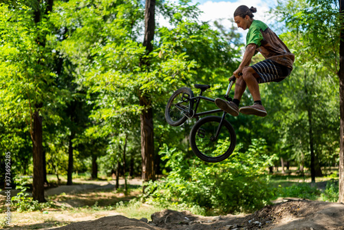 A bmx cyclist doing a trick in flight. Jump on a bike from a springboard.