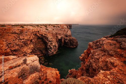 High red cliffs around Sao Vicente cape at south-west corner of Portugal, at the Algarve region.