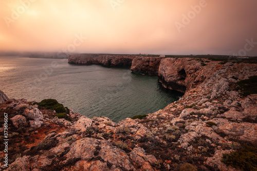 High red cliffs around Sao Vicente cape at south-west corner of Portugal, at the Algarve region.