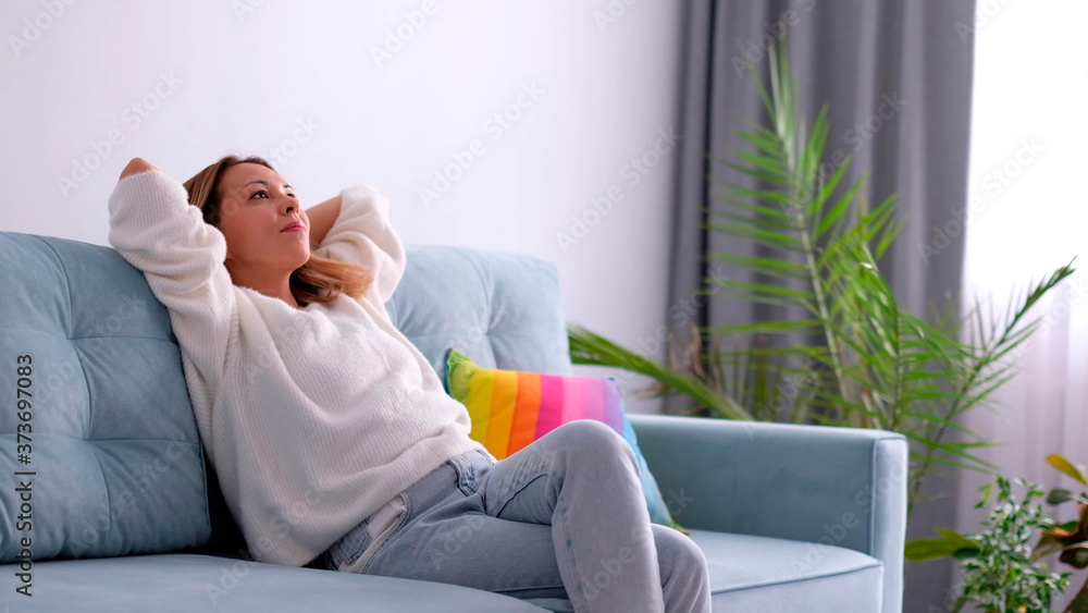 Attractive mid-aged woman relax modern living room on leather sofa Attractive mid-aged woman relax modern living room on leather sofa
