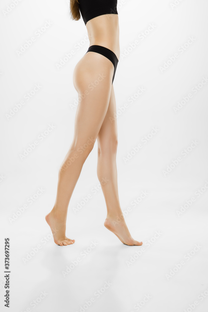 Beautiful female legs and belly isolated on white background. Beauty, cosmetics, spa, depilation, treatment and fitness concept. Fit and sportive, sensual body with well-kept skin in underwear. Beautiful female legs and belly isolated on white background. Beauty, cosmetics, spa, depilation, treatment and fitness concept. Fit and sportive, sensual body with well-kept skin in underwear.