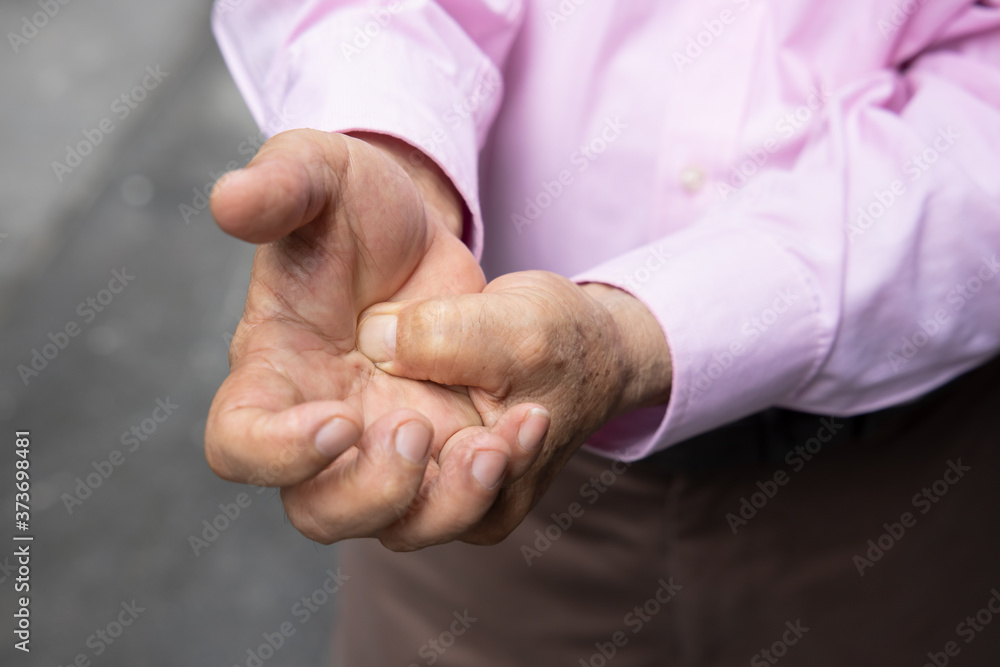 old senior man suffering from trigger finger, cps or carpal tunnel syndrome, gout disease, arthritis inflammation, hand pain; health care or body care concept