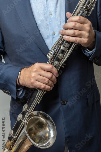 Close-up of male hands holding bass clarinet, cropped photo