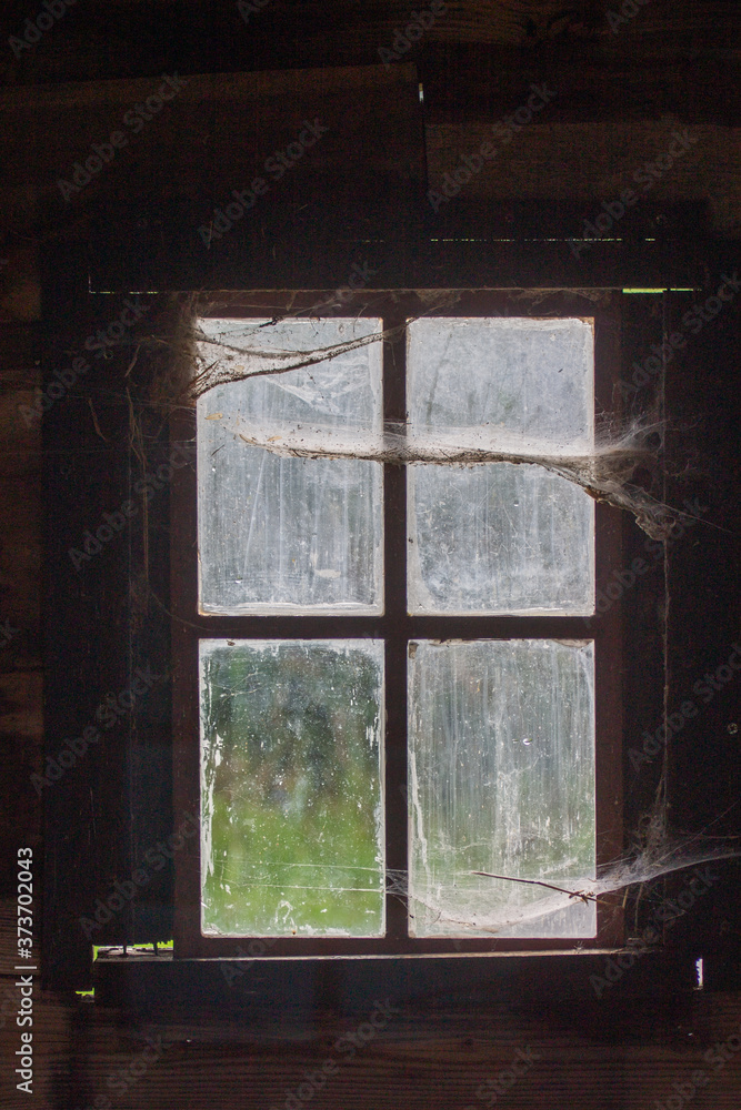 Fototapeta premium Halloween window in old barn with spider webs