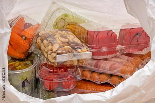 Plastiaksackerl mit Lebensmittel in Sichtverpackung aus Plastik.