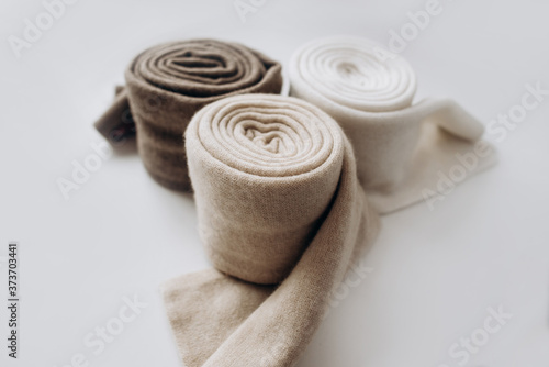 Three rolls of cashmere in different pastel colors with on white background. Selective focus. Close Up view. Blurred background