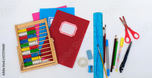abacus, notebooks and various school supplies up close on a white background