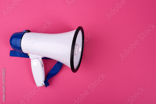 Close up white megaphone. Isolated on a pink background.