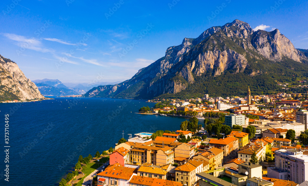Spectacular view of Italian city of Lecco at foot of San Martino mountain on shore of Lake Como overlooking gothic bell-tower of Minor Basilica of San Nicolo, Lombardy..
