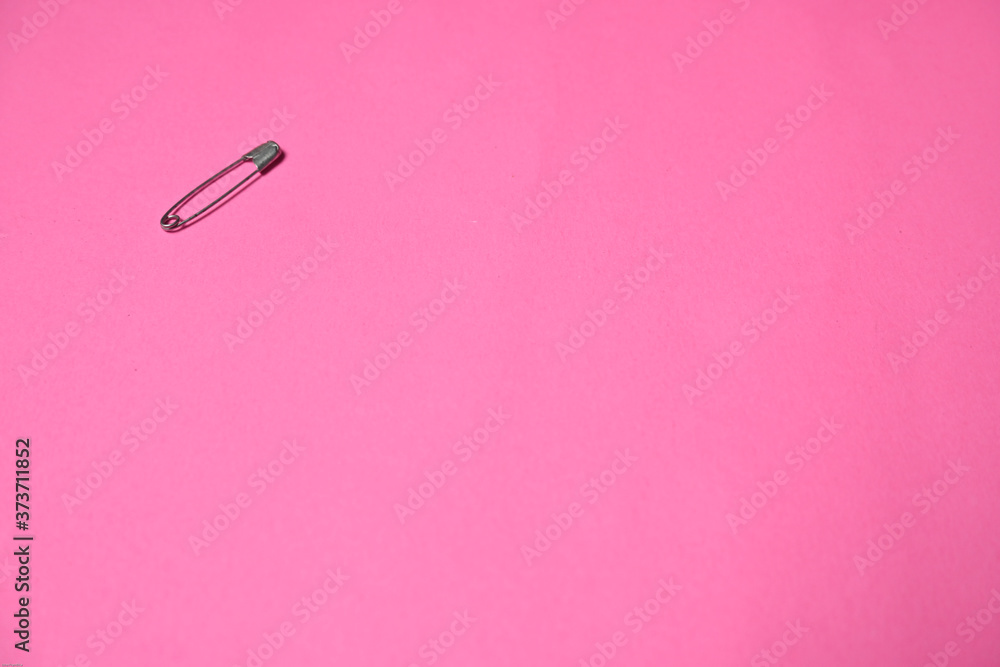 The only one safety pin isolated on pink background The only one safety pin isolated on pink background