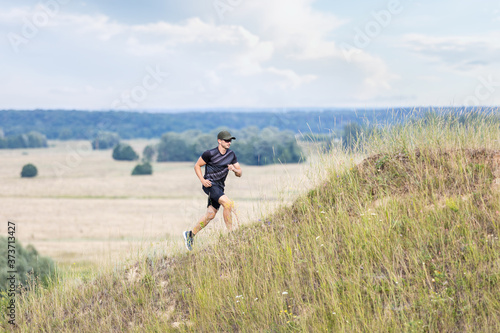 Young man running uphill on trail running workout