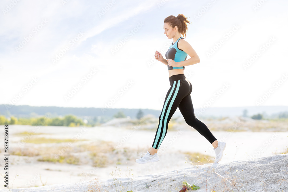 Young fitness runner woman jumping on trail path Young fitness runner woman jumping on trail path