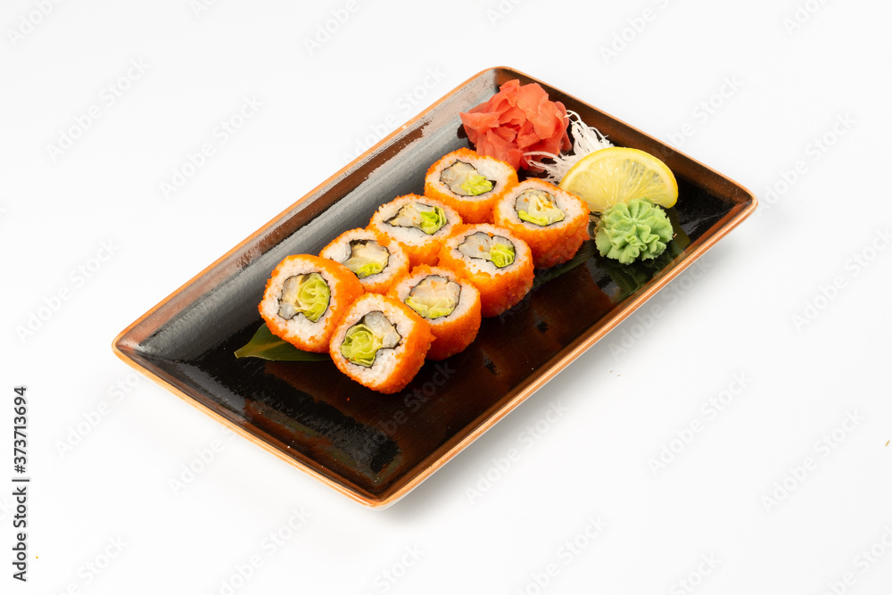 A portion of maki sushi with an assortment of Japanese side dishes in a rectangular ceramic plate on a white plate. A portion of maki sushi with an assortment of Japanese side dishes in a rectangular ceramic plate on a white plate.