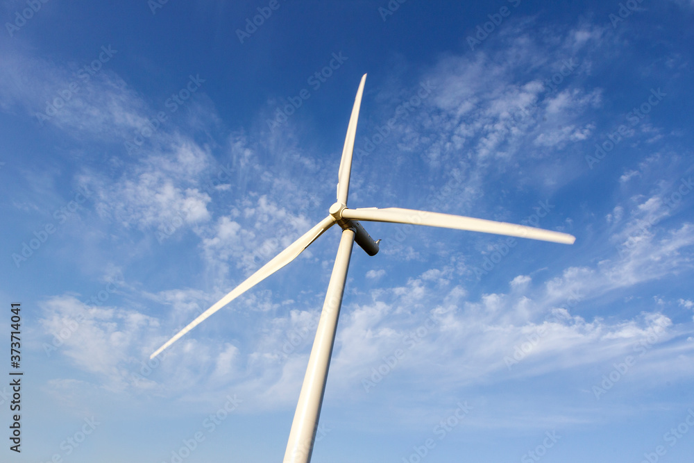 Single wind turbine with blue sky background from directly below. Single wind turbine with blue sky background from directly below.