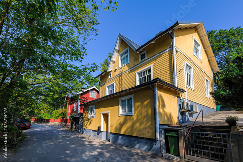 Traditional wooden house painted in traditional falun red and yellow with white window at street of Pargas town (Parainen in Finnish) in Finland at sunny summer day. photo