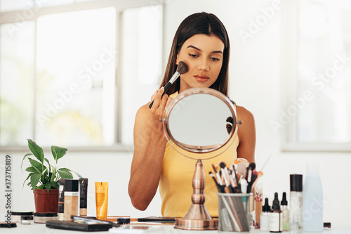 Young latin make-up artist in her makeup room. Small business owners concept.