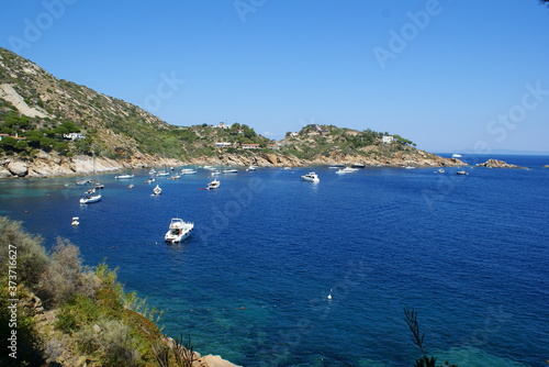 A bay in Giglio Island: the rocky coast and boats off the coast