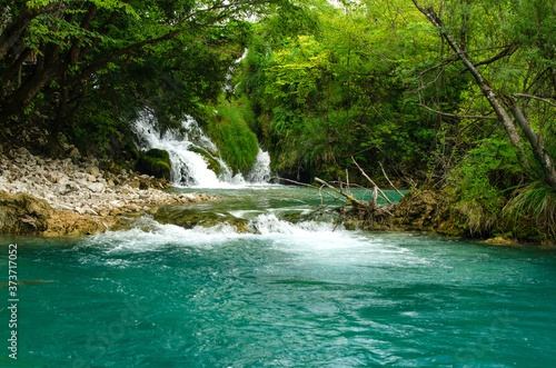 Waterfall and turquoise stream in the forest