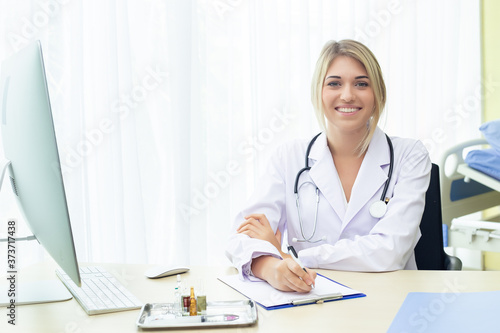 Doctor woman brown hair caucasian beautiful with stethoscope wear uniform looking at camera sitting working table in hospital. health care concept.