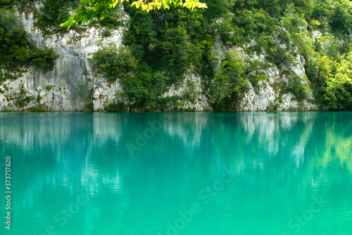 Reflection of rock in the turquoise Plitvice Lake