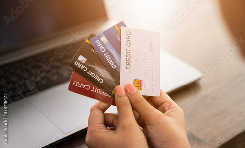 Woman holding a credit card and uses computer laptop to pay online. The concept of online shopping and payment.