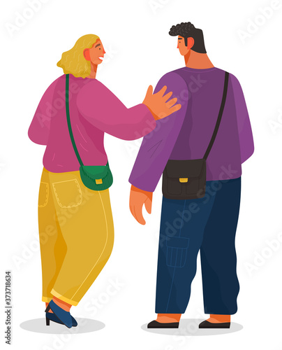 Man and woman talking to each other. Girl glad to meet a friend greets him friendly pat on the shoulder. Male and female characters back view full height. Communication of people. Staff conversation