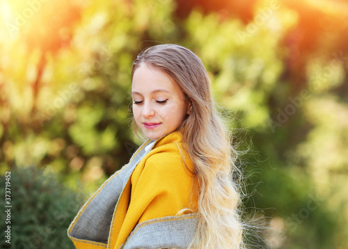 Portrait  of a young girl with luxurious wavy blond hair and blue eyes in a yellow scarf  October. Fashion and beauty.  Autumn concept. Copy space