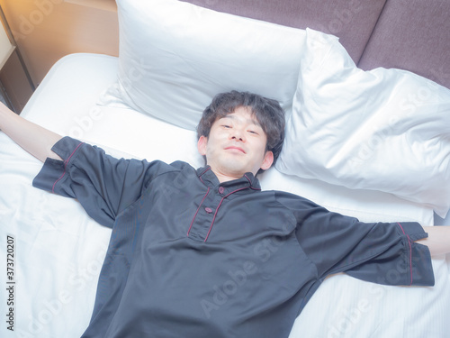 ベットに寝転ぶ男性