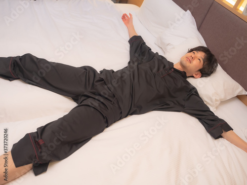 ベットに寝転ぶ男性