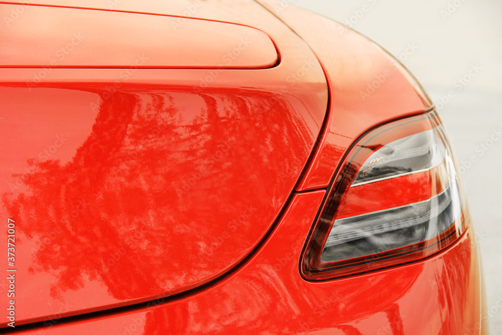 Car headlights. Luxury Headlights. Part of a red car close up. Bumper