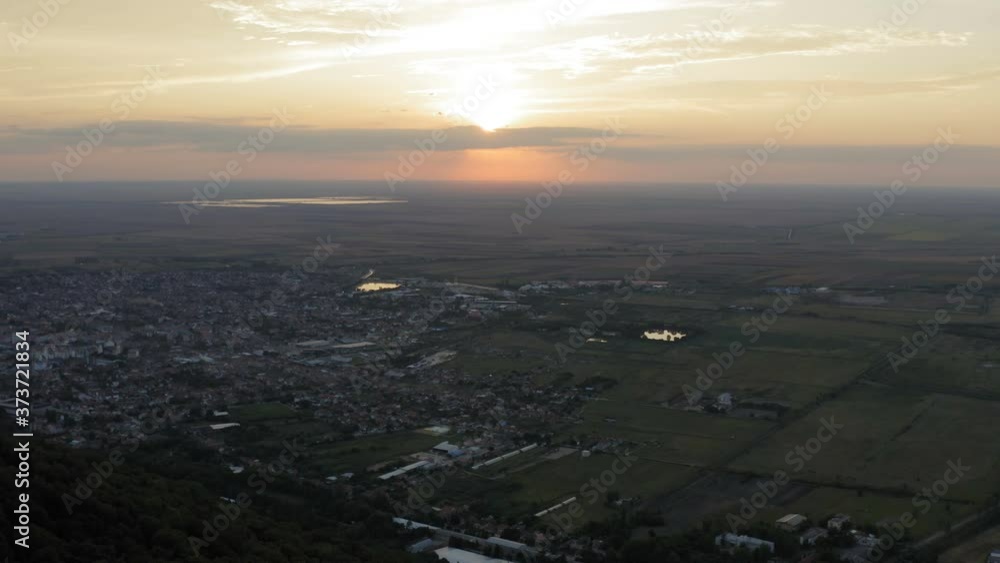 sunset with a panorama of the city in the plain and a medieval tower on top of the hill.drone aerial moving shot sunset with a panorama of the city in the plain and a medieval tower on top of the hill.drone aerial moving shot