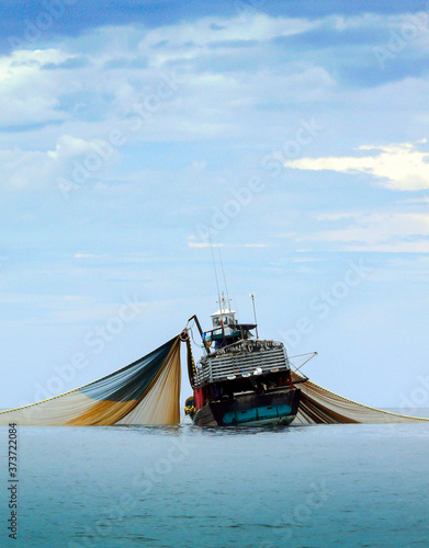 Large fishing trawlers are fishing in the sea.