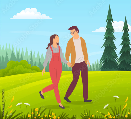 Couple walking in a forest. Young guy and girl holding hands walking in summer garden, romantic walk. Lovers man and woman met on a date outdoor. Happy promenade in the open air, active lifestyle