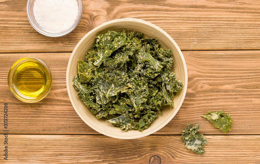 Kale chips on a wooden table. View from above. Rustic Kale chips on a wooden table. View from above. Rustic