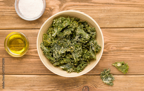 Kale chips on a wooden table. View from above. Rustic