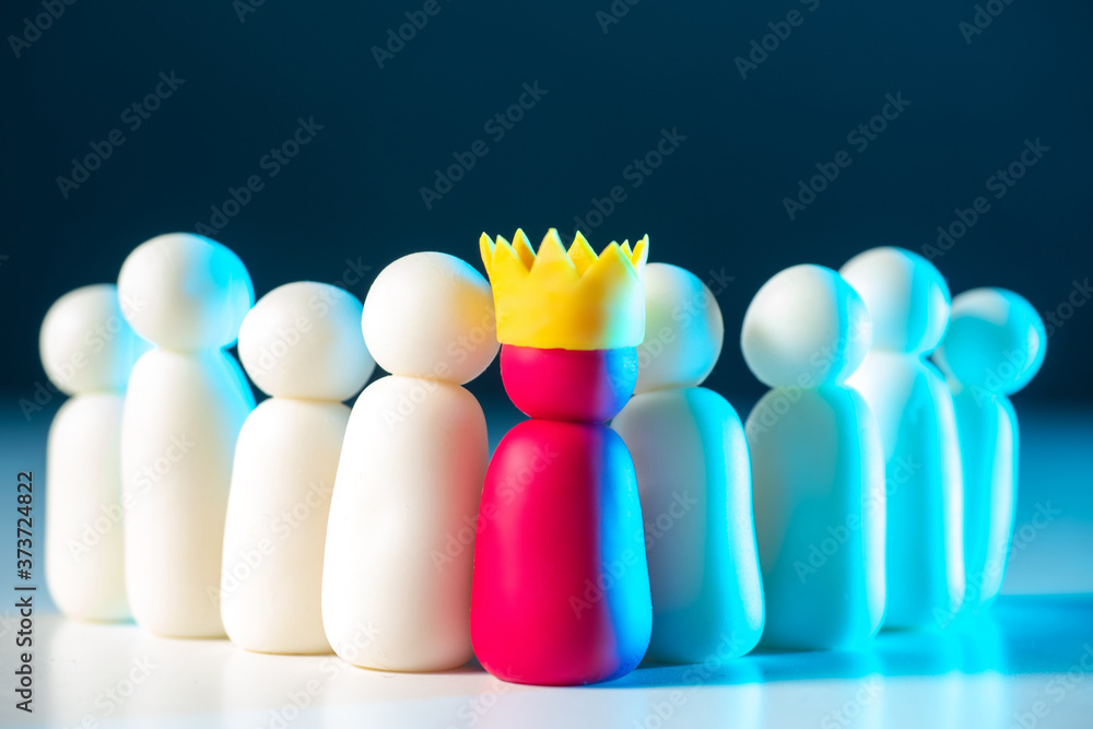 Teamwork concept. The group of little men is led by a man in a crown. Teamwork under the management of the best. Managerial talent. A fair assessment of the business qualities.