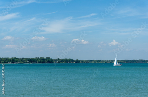 sailboat in distance on a clear blue lake 