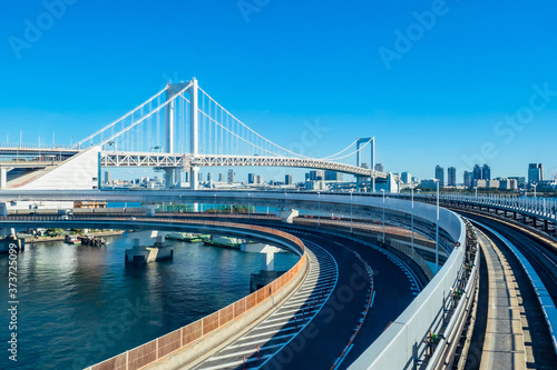 Japan. Railway tracks and highway on the background of the Rainbow bridge. Transport on the island of Odaiba. Travel to the Japanese capital. Transport infrastructure. Travel to Japan.