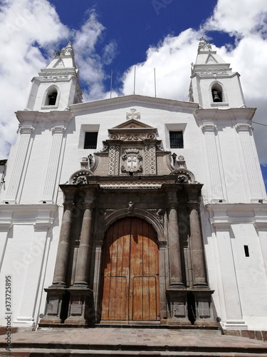 Old church seen from the front in sunny day. El Carmen Alto church in Quito, Ecuador, view of its main entrance with blue sky and clouds.