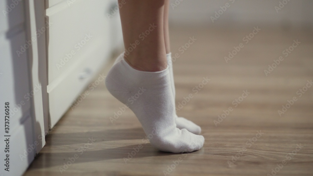 Woman is socks getting out of bed and go out