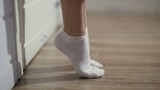 Woman is socks getting out of bed and go out