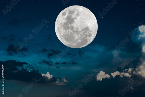 Full moon over clouds on the sky.
